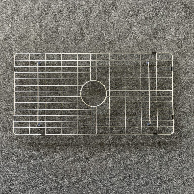 Stainless steel sink grid on a textured surface.