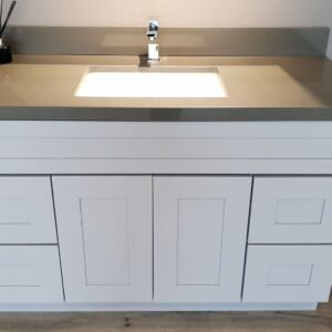 Modern white bathroom vanity with gray countertop and sink.