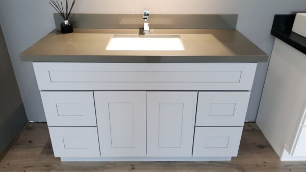 Modern white bathroom vanity with gray countertop and sink.
