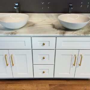 White marble double sink vanity with gold handles on wooden floor.