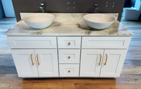 White marble double sink vanity with gold handles on wooden floor.
