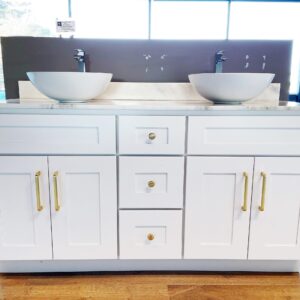 White bathroom vanity with dual sinks and gold handles.