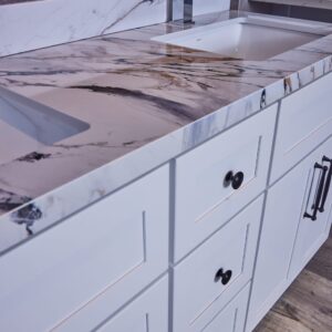 Marble countertop with white cabinets in modern kitchen.
