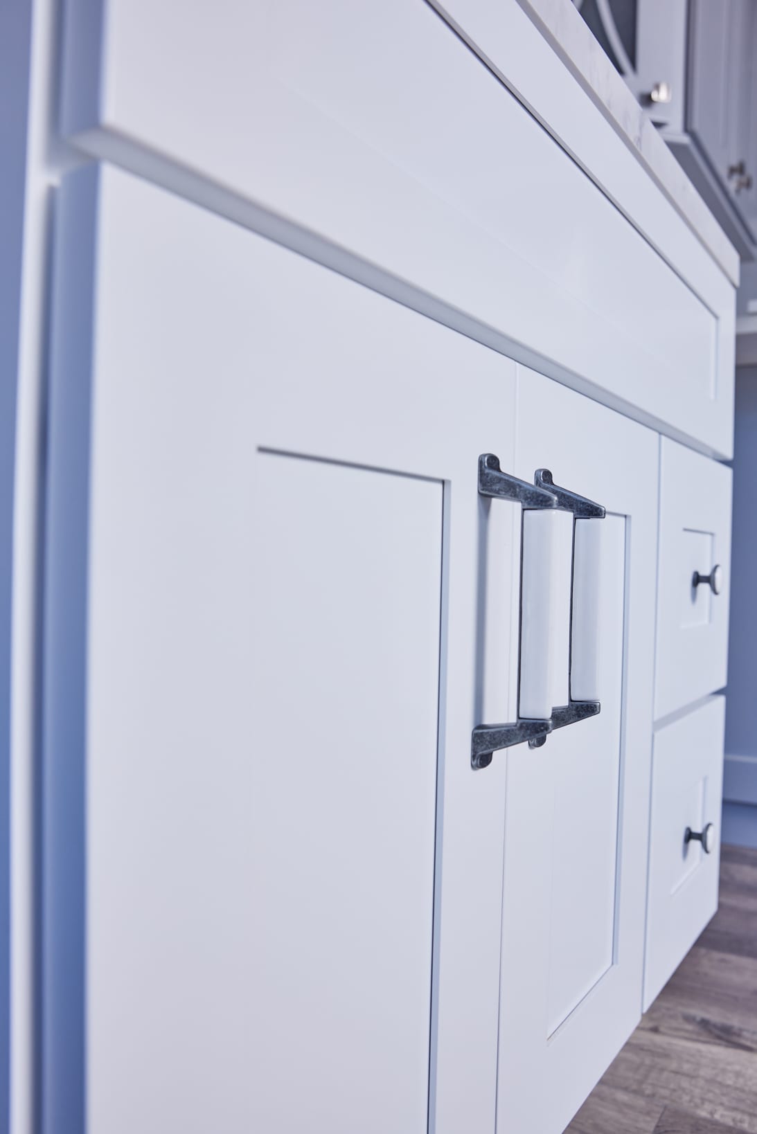 White kitchen cabinet with modern black handles.