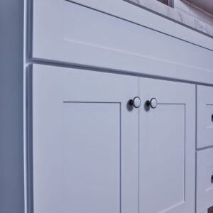 White kitchen cabinet with modern handles.