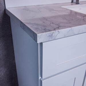 White bathroom vanity with marble countertop and modern faucet.
