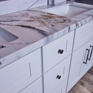 Marble countertop with white cabinets in a modern kitchen.