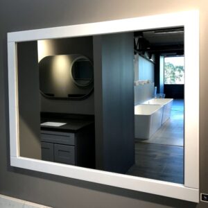 Modern bathroom showroom with large mirror and sleek fixtures.