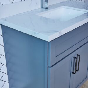 Blue bathroom vanity with marble countertop and modern handles.