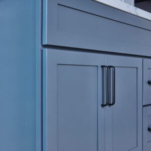 Blue kitchen cabinet with black handles.