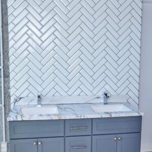 Modern bathroom with herringbone tile backsplash and double sink vanity.