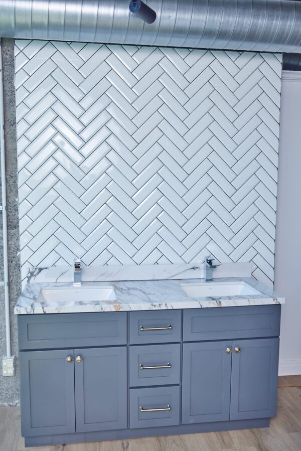 Modern bathroom with herringbone tile backsplash and double sink vanity.