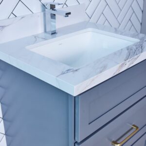 Modern bathroom vanity with marble countertop and herringbone tile backsplash.