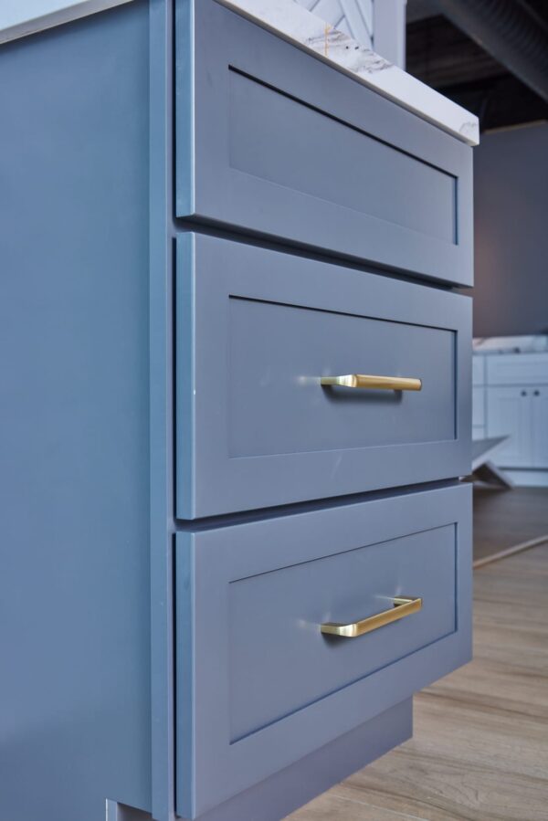 Blue kitchen cabinets with gold handles in modern design.