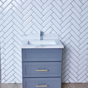 Gray bathroom vanity with herringbone tile backsplash.