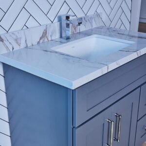 Modern bathroom vanity with marble countertop and blue cabinet.