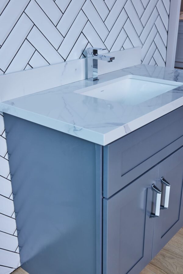 Blue bathroom vanity with marble countertop and modern faucet.