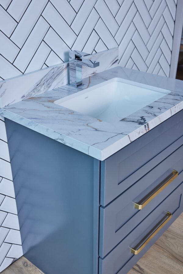Blue bathroom vanity with marble countertop and modern faucet.
