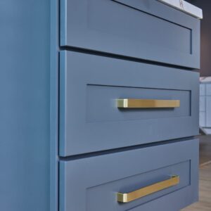 Blue kitchen drawers with gold handles.