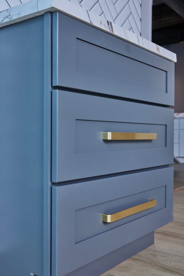 Blue kitchen drawers with gold handles.