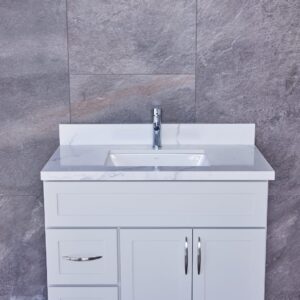 White bathroom vanity with marble countertop and modern faucet.