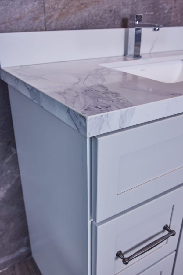Modern bathroom vanity with marble countertop and chrome faucet.