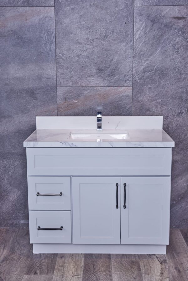 White bathroom vanity with marble countertop and gray tile background.