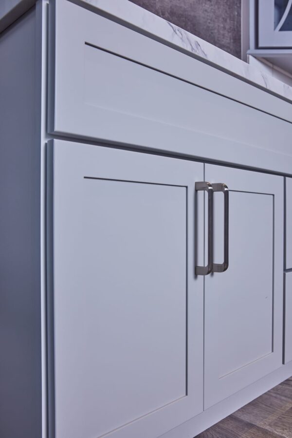 White kitchen cabinet with modern handles.