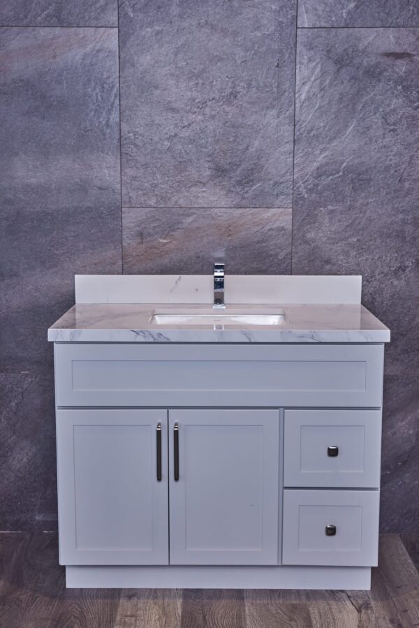 Modern bathroom vanity with marble countertop and gray tile backsplash.