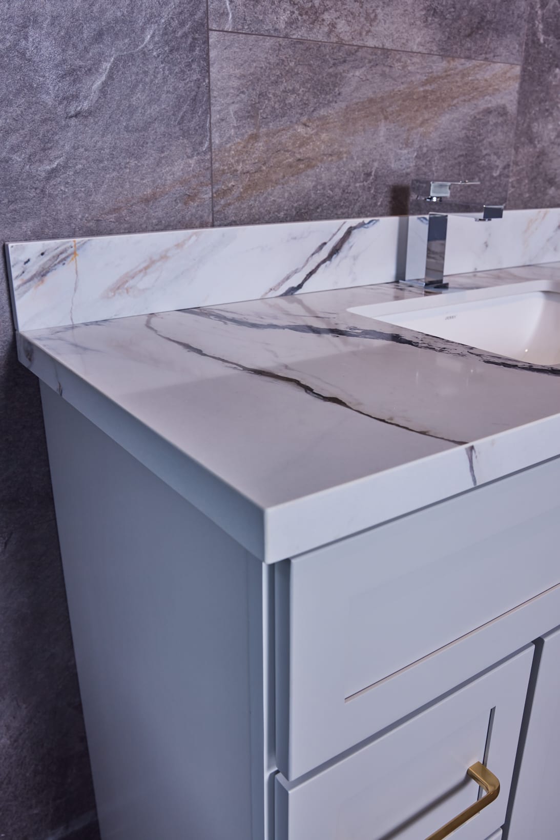 Marble bathroom vanity with modern faucet and backsplash.