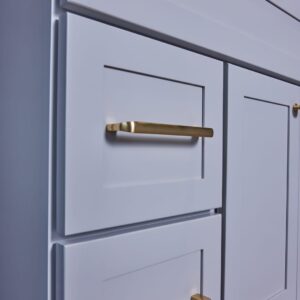 White kitchen cabinets with gold handles.