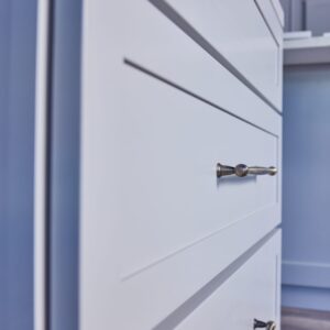 White kitchen cabinet with sleek metal handle.