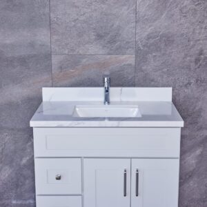 White bathroom vanity with marble countertop and modern faucet.