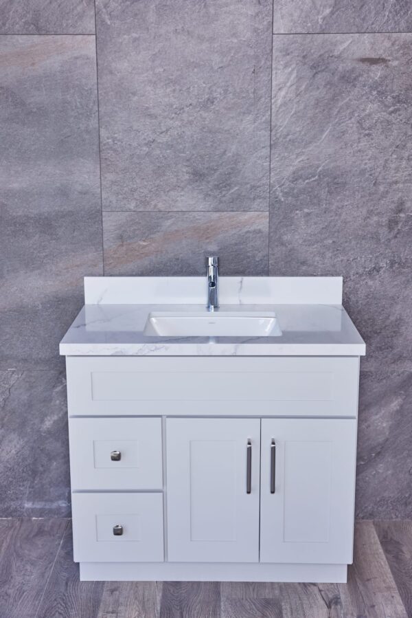 White bathroom vanity with marble countertop and modern faucet.
