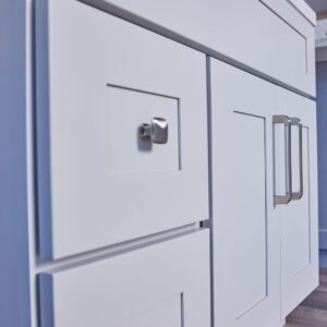 White kitchen cabinets with modern handles in a blue-themed kitchen.