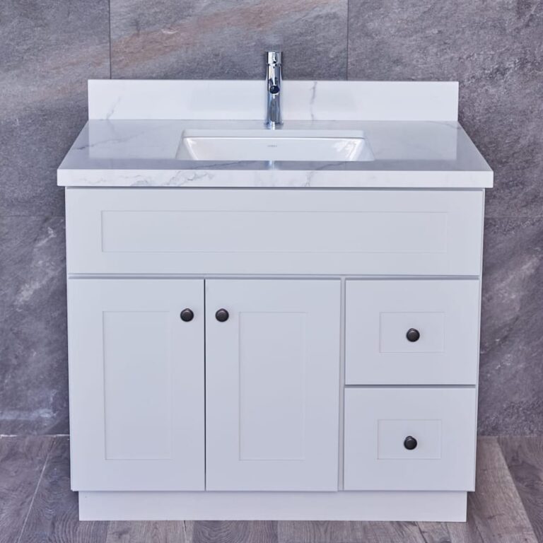 White bathroom vanity with marble countertop and chrome faucet.