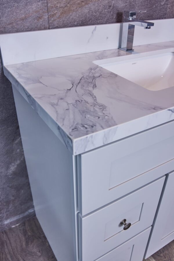 Modern bathroom vanity with marble countertop and sleek faucet.