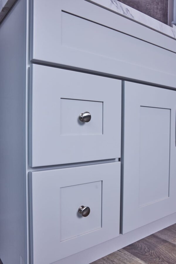White kitchen cabinet with silver knobs.