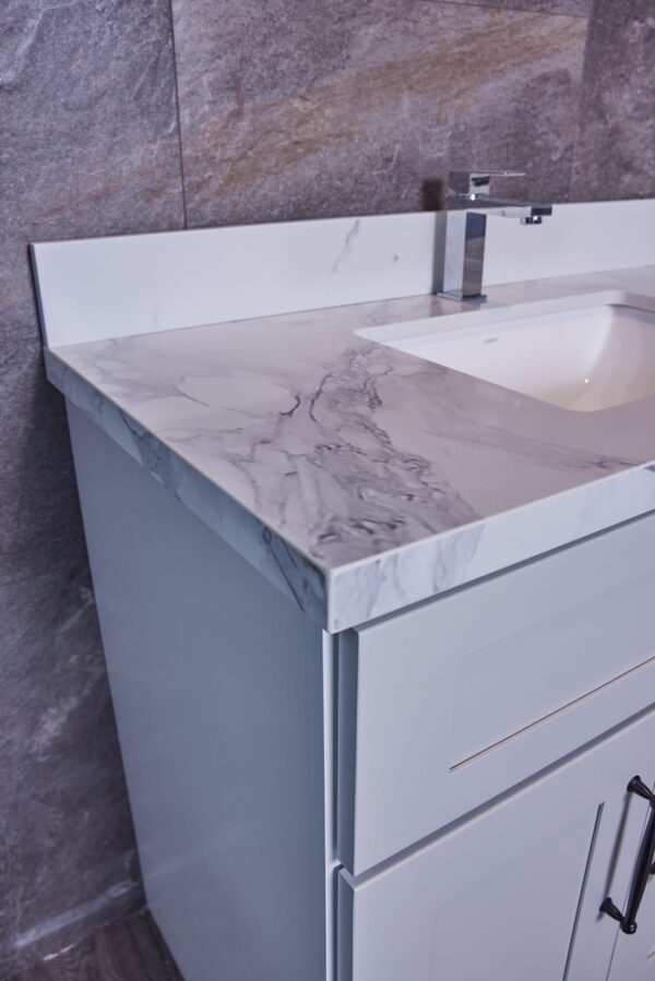 Modern bathroom vanity with marble countertop and sleek faucet.