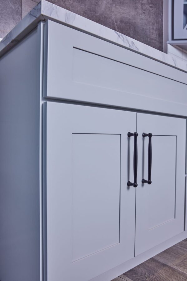 White kitchen cabinet with black handles.