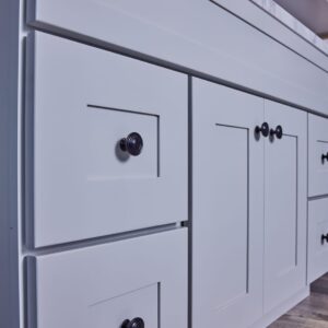 White kitchen cabinets with black knobs.