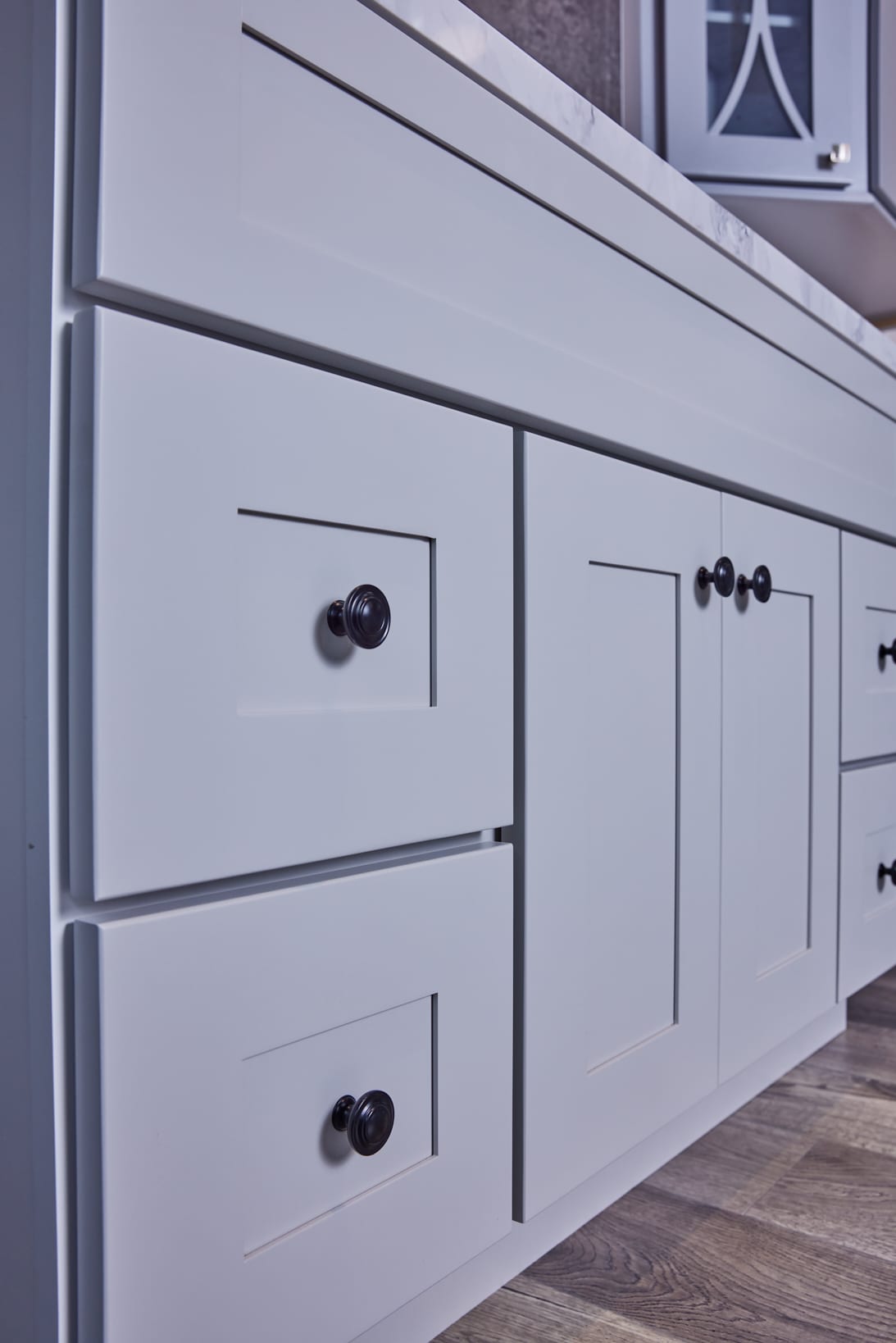 White kitchen cabinets with black knobs.