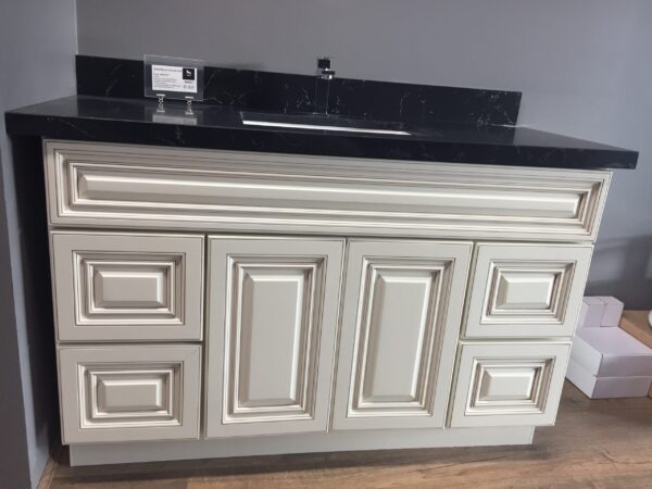White kitchen cabinet with black countertop and sink.