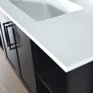 Modern kitchen countertop with white surface and dark cabinets.
