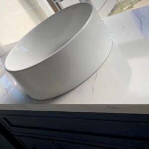 White ceramic sink on marble countertop in modern kitchen.