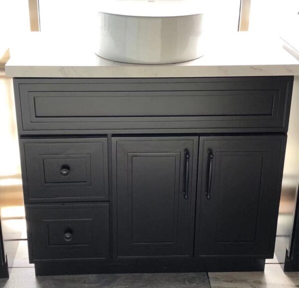 Black kitchen cabinet with drawers and a white countertop.