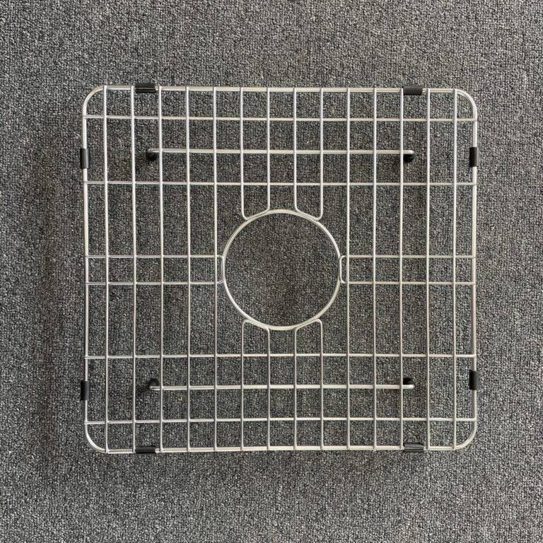 Square metal sink grid on a gray carpet background.