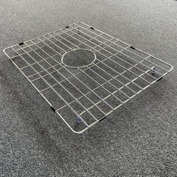 Stainless steel sink grid on gray carpet.