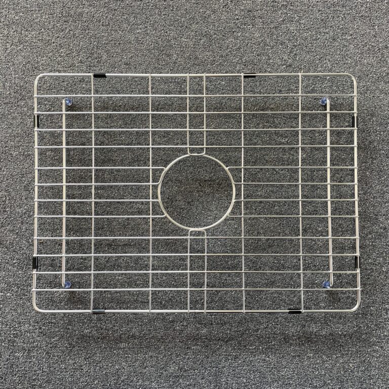 Stainless steel sink grid on a textured surface.
