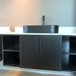 Modern black bathroom vanity with open shelves and a sleek sink.